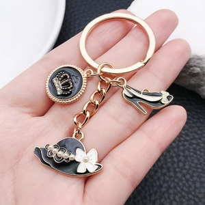 Porte-clés doré élégant avec pendentifs émail noir couronne, escarpin et chapeau de dame