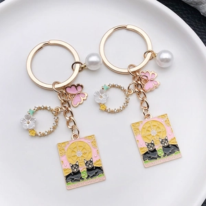 Porte-clés chat tarot roue de la fortune rose avec papillon et perle charms
