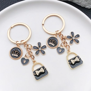 Porte-clés doré élégant avec pendentif sac à main noir et breloques cœur couronne