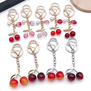 Creative resin cherry keychains with pearl charms and chains in various vibrant colors