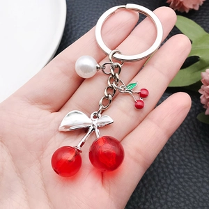 Translucent red cherry keychain with silver bow, pearl bead, and small cherry charm