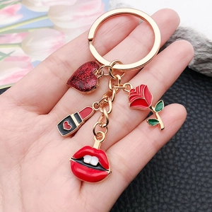 Porte-clés en alliage doré tenu à la main avec breloques émaillées cœur, rouge à lèvres et rose