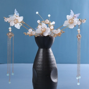 Detailed macro view of vintage Chinese hairpins with white flowers and blue tassels