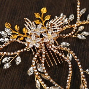 Dettaglio macro del pettine da sposa dorato con fiori di cristallo e lunghe nappe di strass