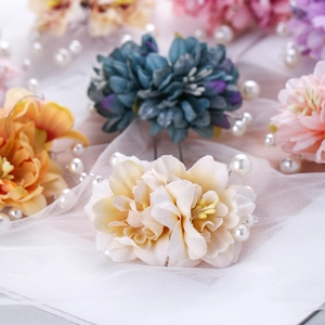 Détail d'épingles à cheveux en fleurs de tissu avec perles pour coiffure vintage