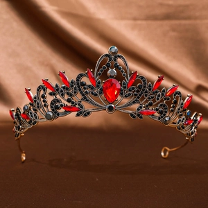 Detailed shot of a vintage gold bridal crown with red gemstones and black crystals