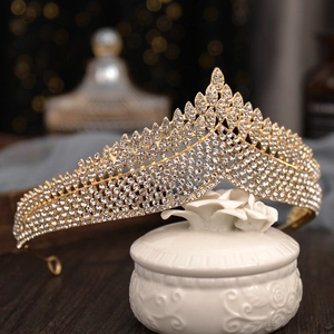 Close-up of a sparkling gold rhinestone bridal crown on a decorative ceramic jar