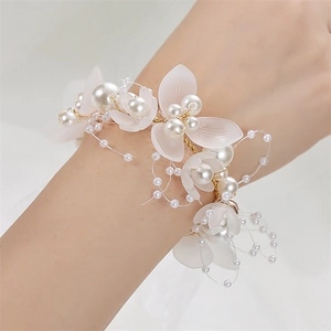 Close-up of a bridal wrist flower featuring white frosted petals and elegant pearls