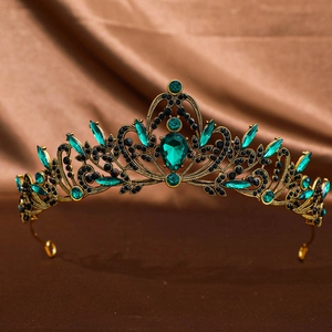 Detailed close-up of emerald green pear-shaped gemstones on a vintage gold tiara