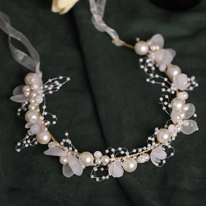 Exquisite bridal wrist corsage with white pearls and silk petals on deep green velvet