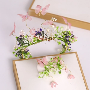 Détail d'une couronne de mariée féerique avec papillons en tulle rose et perles
