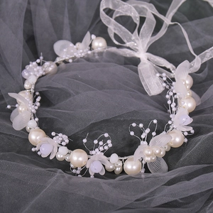 Detailed shot of pearl wedding wrist corsage with white petals and organza ribbons