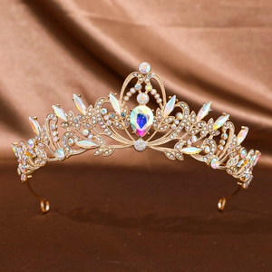 Detail of a luxurious golden crown featuring colorful rhinestones on a silk background