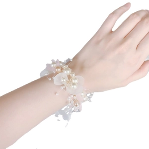 Elegant bridal wrist corsage with white pearls and frosted petals for wedding accessories
