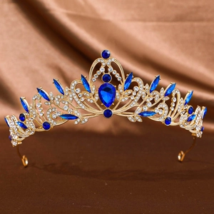 Elegant gold bridal crown with brilliant blue gemstones and crystals on silk background
