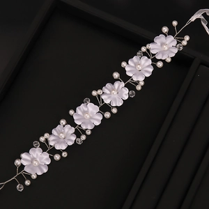 Détail d'un bandeau de mariée fait main avec fleurs en satin et perles blanches
