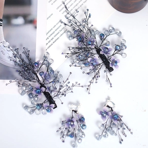 Detail of handcrafted floral bridal hair clips and earrings set with blue crystals