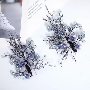 Detail of handmade bridal hair clips with purple fabric flowers and blue crystal beads