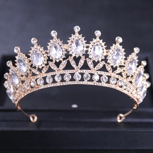 Gros plan d'une couronne de mariée dorée ornée de strass brillants sur fond noir élégant