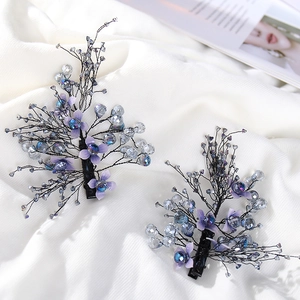 Detailed macro view of handmade purple crystal flower hair clips for bridal styling