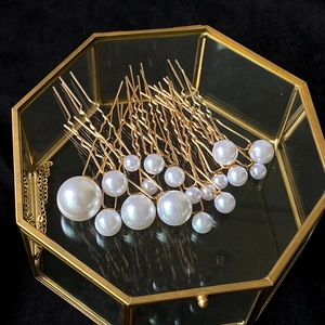 Lot d'épingles à cheveux dorées avec perles présentées dans une boîte en verre