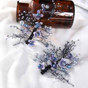 Floral bridal hair clips with purple petals and crystals on white silk background