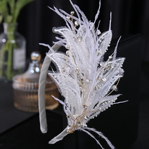 Serre-tête de mariée en plumes blanches avec perles et strass sur fond noir élégant
