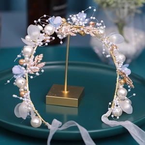 Detailed view of handmade bridal headband with gold leaves, blue resin flowers and pearls