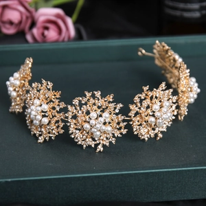 Gros plan d'un serre-tête doré avec motifs floraux, strass blancs et perles d'imitation