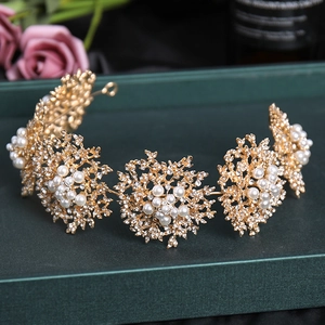 Serre-tête doré élégant avec perles blanches et strass sur une boîte cadeau verte