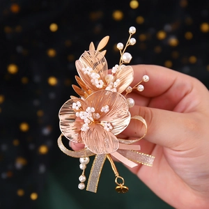 Detailed close-up of handmade rose gold flower hairpiece with pearls and ribbons