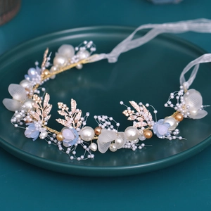Handmade bridal pearl headband with gold leaves and blue petals for wedding hair styling