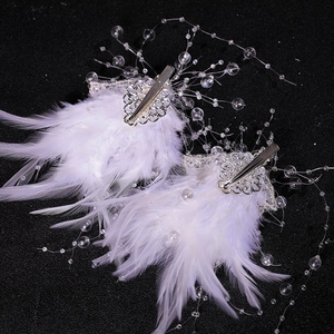 Detailed macro shot of white feather hair clips with silver floral metal and crystal beads