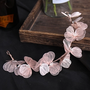 Detail of handmade bridal hairpiece with pink wire lace flowers and white pearls