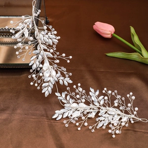 Elegant bridal hair vine with pearls, crystals, and silver leaves on velvet background