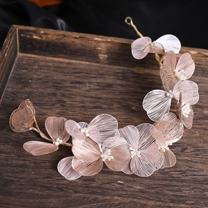 Macro shot of rose gold mesh flowers and pearls on vintage style bridal hair accessories