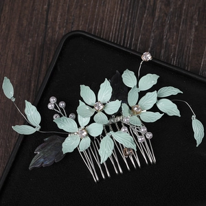Elegant mint green leaf bridal hair comb with pearls and rhinestones on a black background