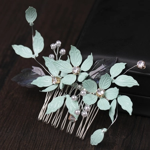 Detail of mint green floral bridal hair comb with pearls and rhinestones on wood