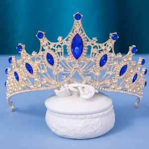 Detail of luxury baroque gold bridal crown with deep blue gemstones and sparkling crystals