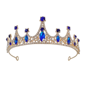 Close-up of golden bridal tiara with sparkling blue gemstones and clear rhinestones