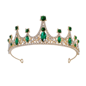 Detail of gold alloy bridal crown with emerald green gems and sparkling rhinestones