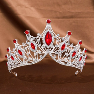 Macro view of silver baroque crown featuring red teardrop crystals and clear rhinestones