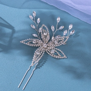 Detailed macro view of silver bridal hair pin with sparkling rhinestones and floral vine design