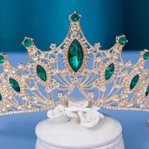 Golden baroque bridal crown with emerald green gemstones and sparkling clear rhinestones