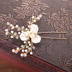 Détail de l'épingle à cheveux en U faite main avec fleurs de perles et fils dorés