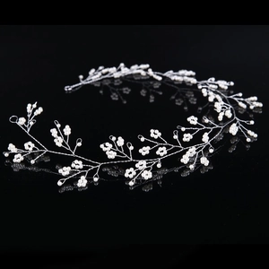 Elegant bridal pearl hair vine with silver wire floral clusters on a reflective black base