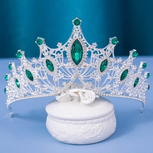 Silver vintage bridal tiara with emerald green crystals on white ceramic box