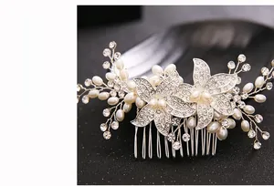 Detail of silver bridal hair comb featuring floral crystals and white faux pearls