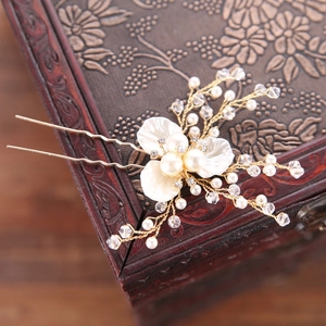 Détail de l'épingle à cheveux fleurie avec perles et cristaux sur coffret en bois