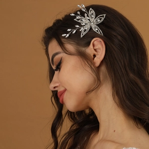 Exquisite bridal rhinestone flower hair pin with silver floral design on wavy hair